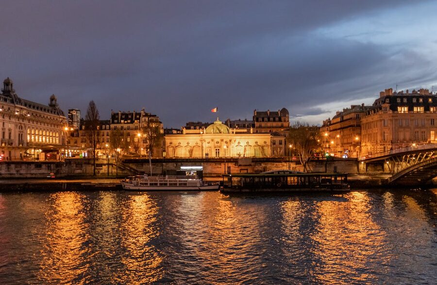 Illuminated Parisian bridges and landmarks reflecting in the Seine river at night