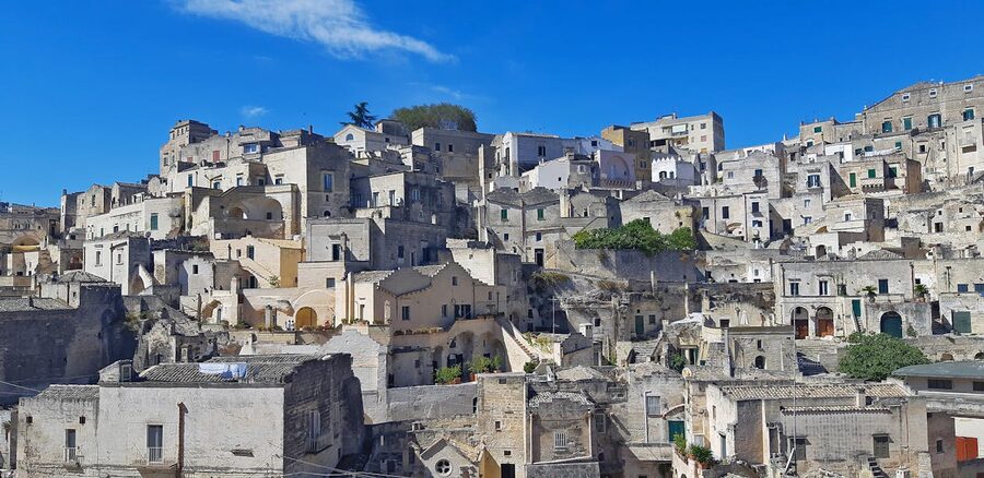 Stone cave houses against dramatic landscape in Matera Italy