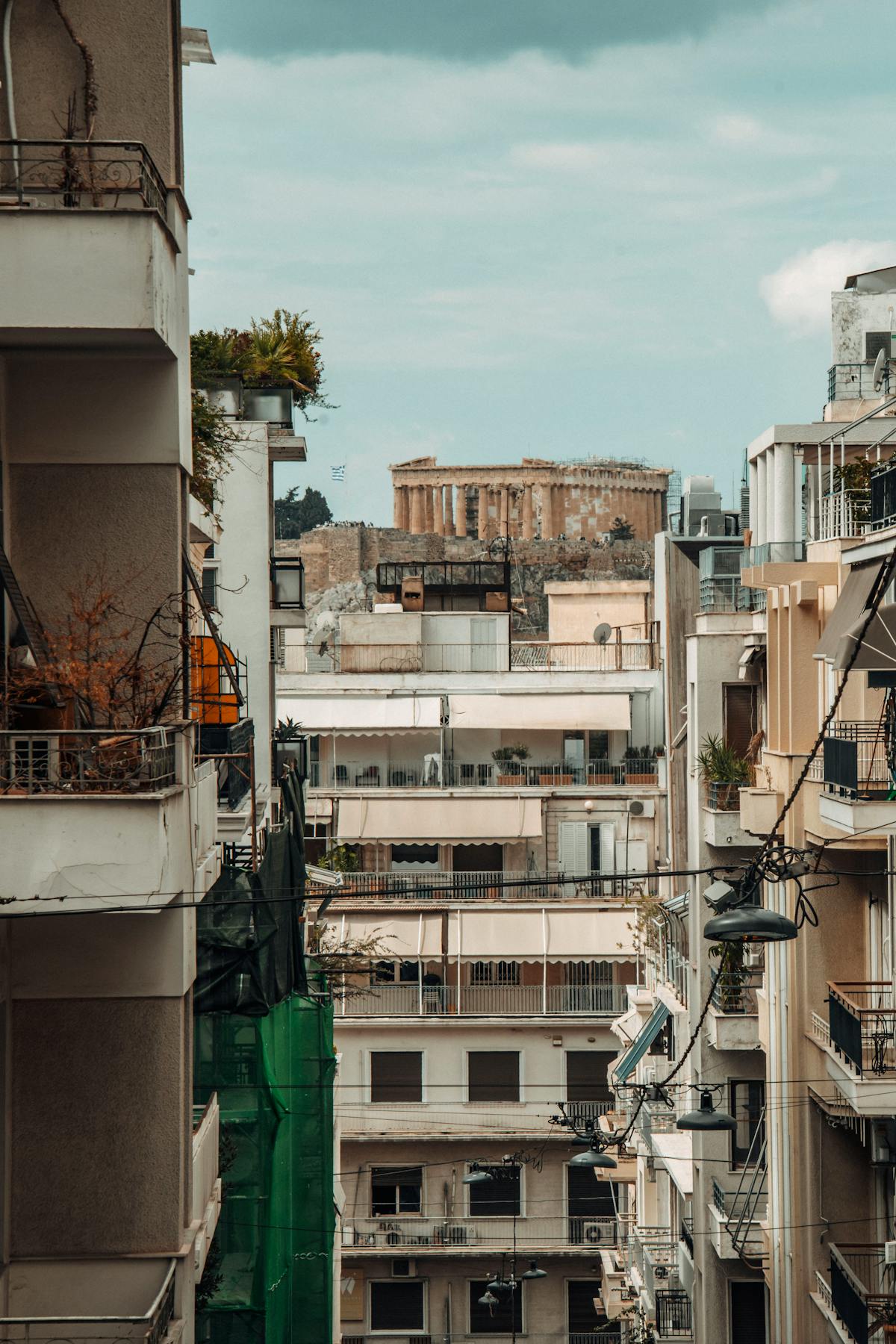 Athens street with the Parthenon visible in the background between modern buildings