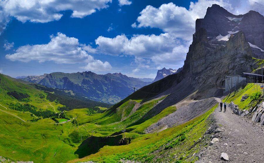 Wide panoramic view of the Swiss Alps with green meadows from Grindelwald