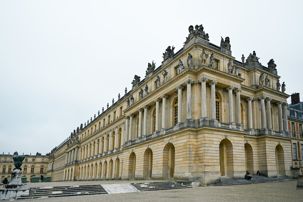 The grand facade of the Palace of Versailles with its ornate architecture and grounds