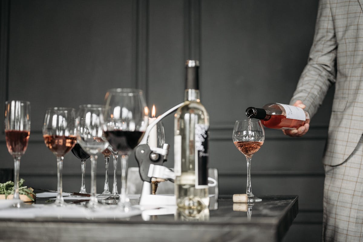 Close-up of a wine tasting session with a sommelier pouring rose into a glass