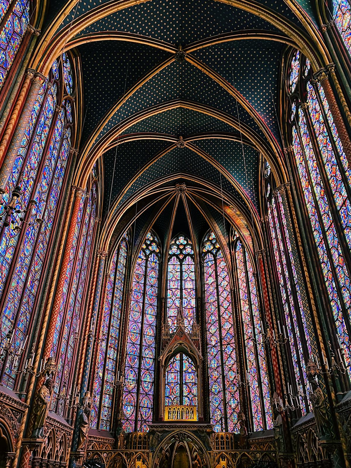 Sunlight streaming through the medieval stained glass of Sainte-Chapelle in golden tones