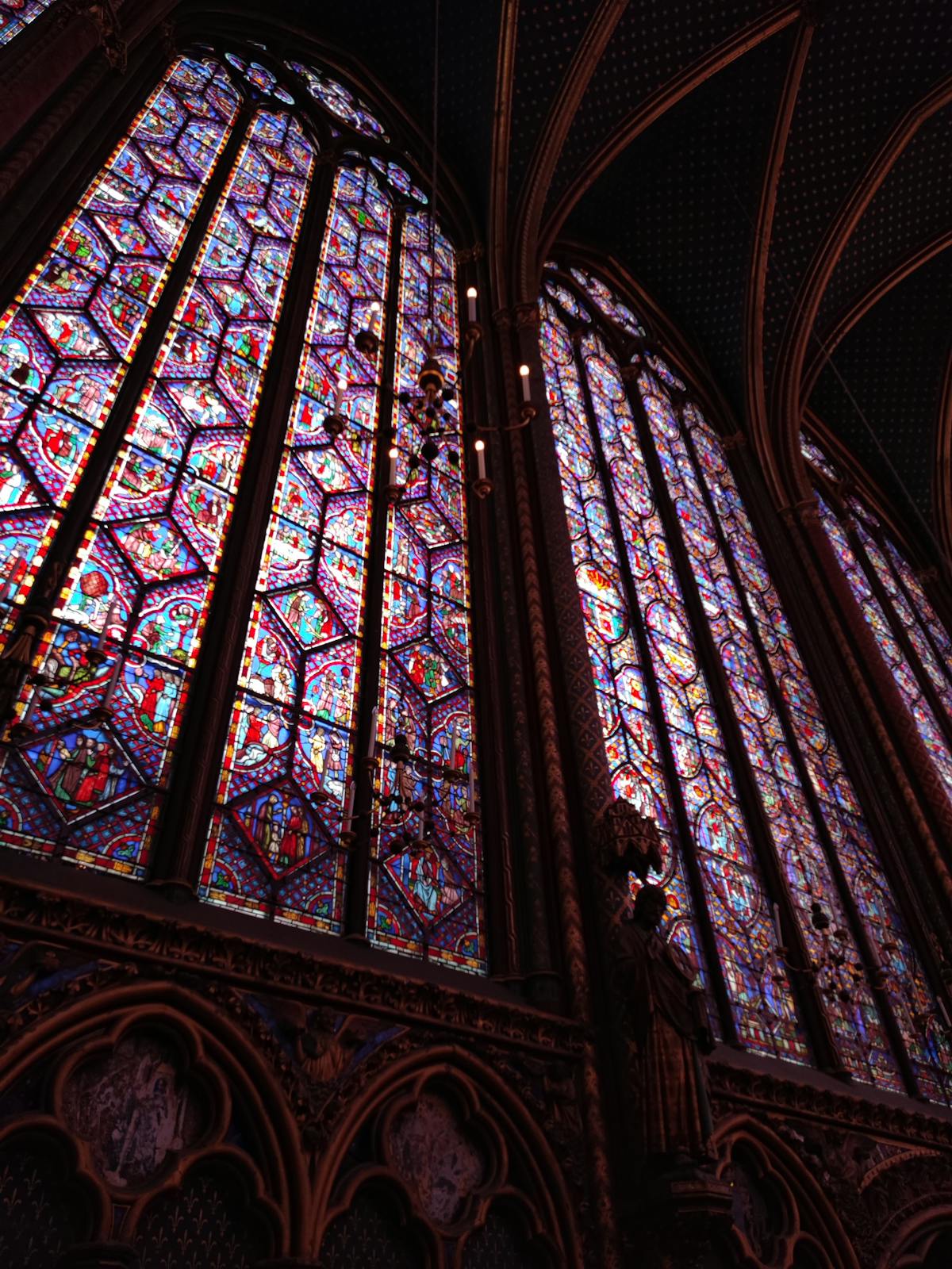 Radiant Gothic stained glass panels reaching toward the vaulted ceiling of Sainte-Chapelle