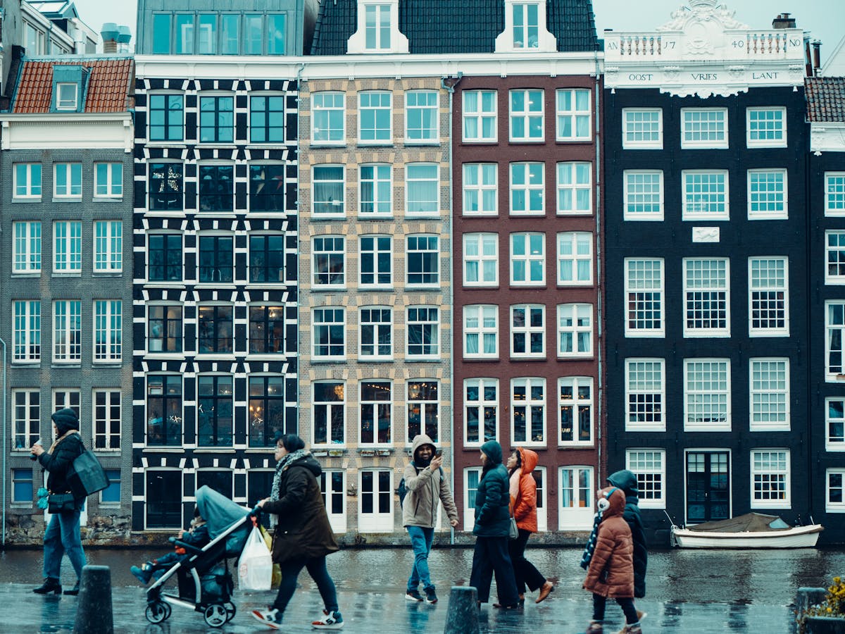 People walking along Amsterdam canal in the rain