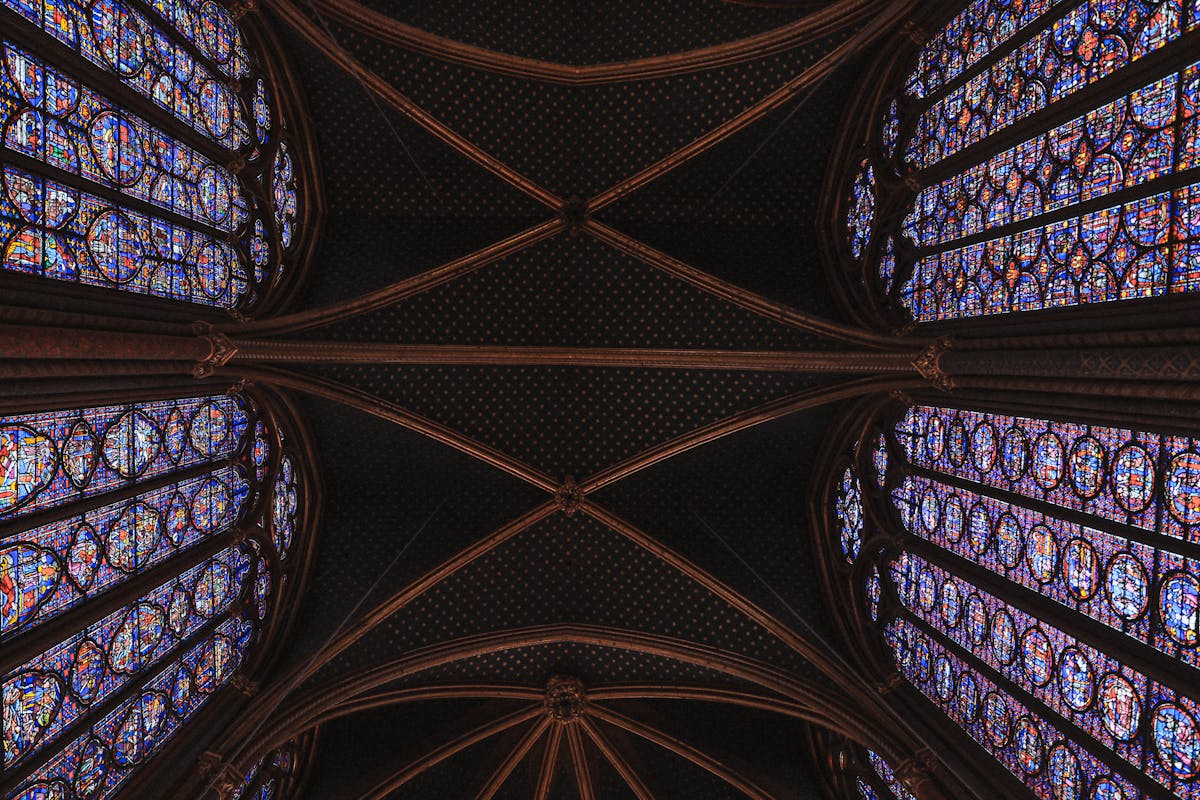 Looking straight up at the ornate Gothic ceiling and stained glass of the upper chapel