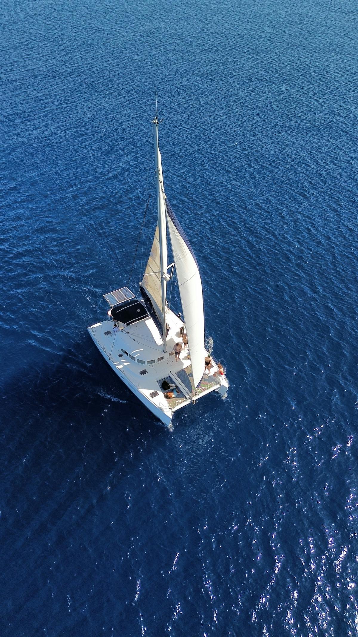 Aerial view of a sailboat cruising on the open blue sea