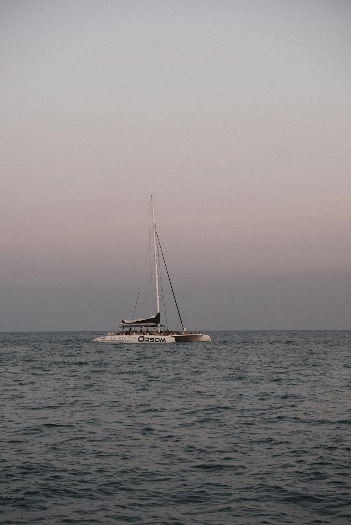 Sailing catamaran on the calm sea at sunset in Barcelona Spain
