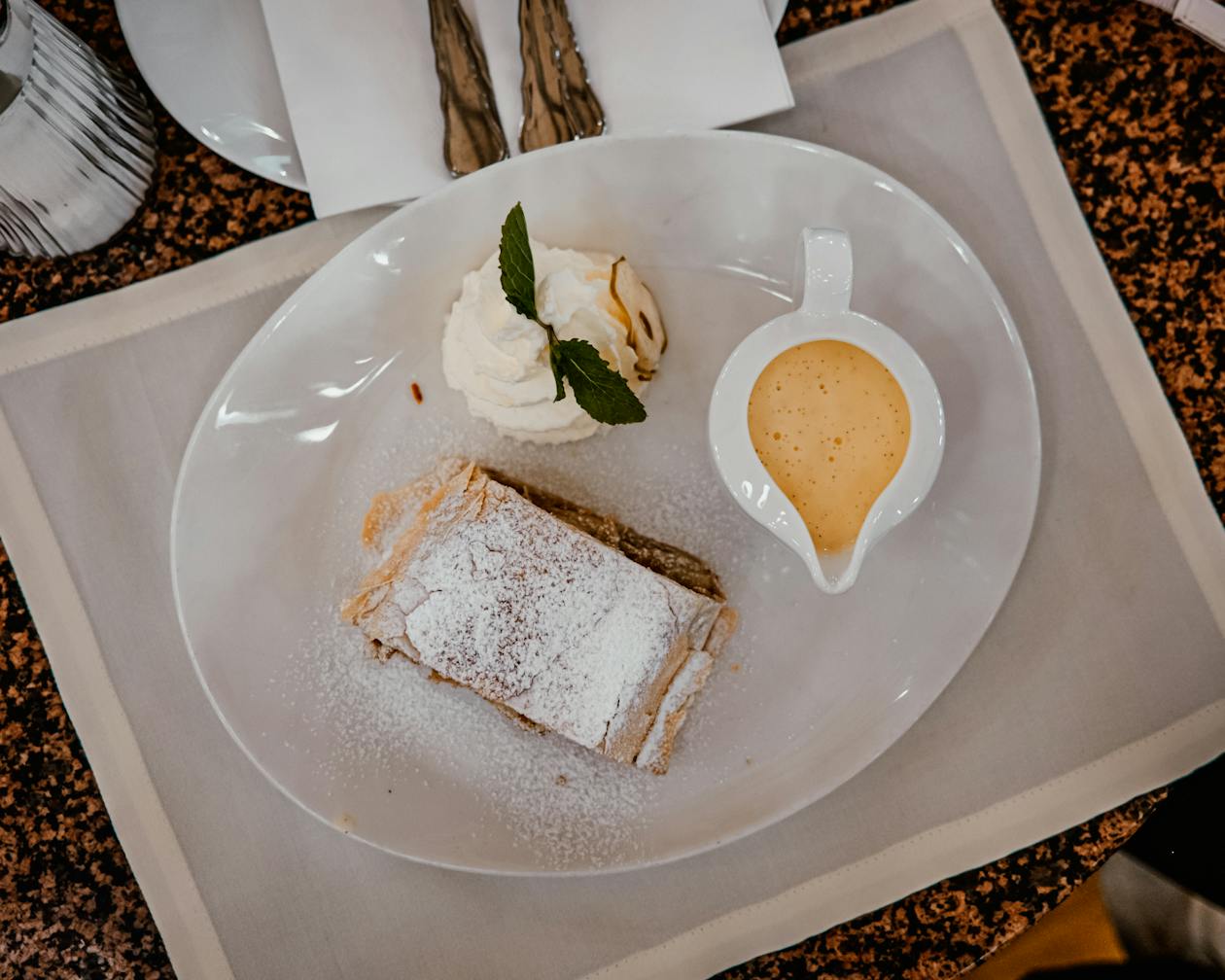 Apple strudel served with whipped cream and vanilla sauce