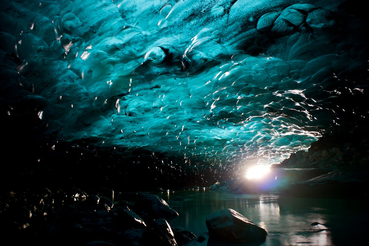 Natural blue ice cave formation in Iceland showing light filtering through glacial ice