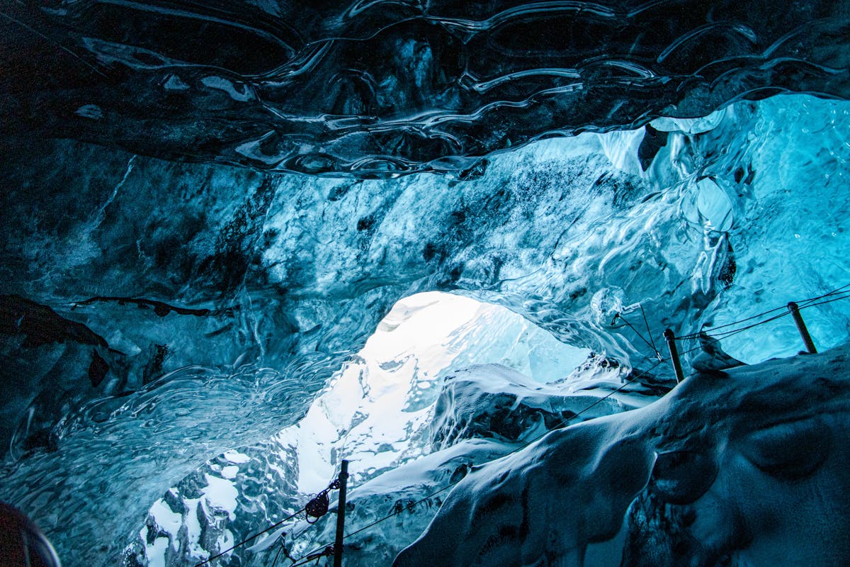 Blue ice cave interior in Iceland with layered glacial ice overhead