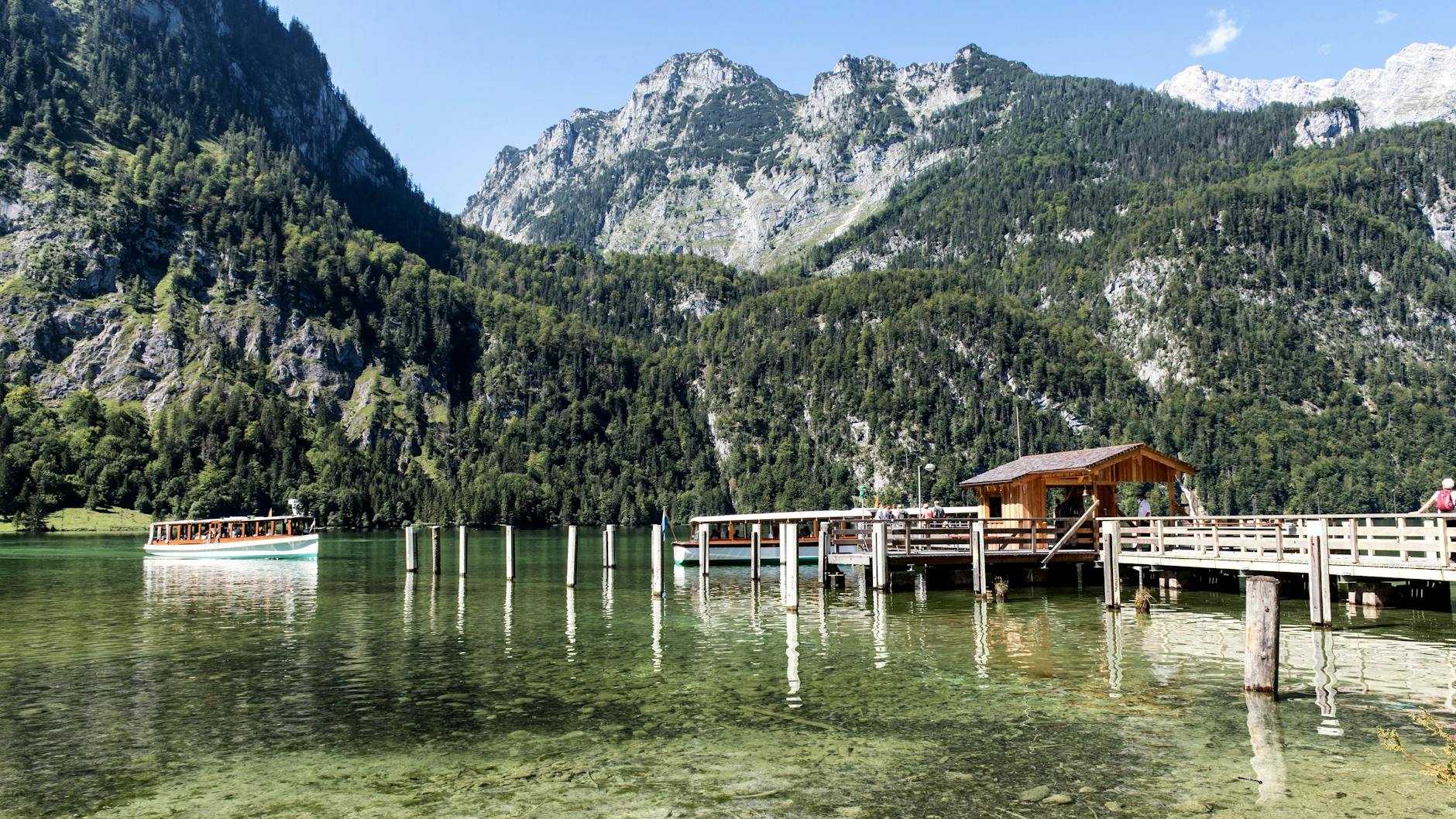 Scenic wooden pier and tour boat on Konigssee lake in Bavaria