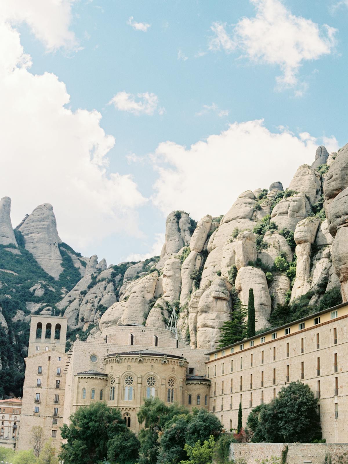 The courtyard of Montserrat basilica with dramatic mountain peaks rising behind