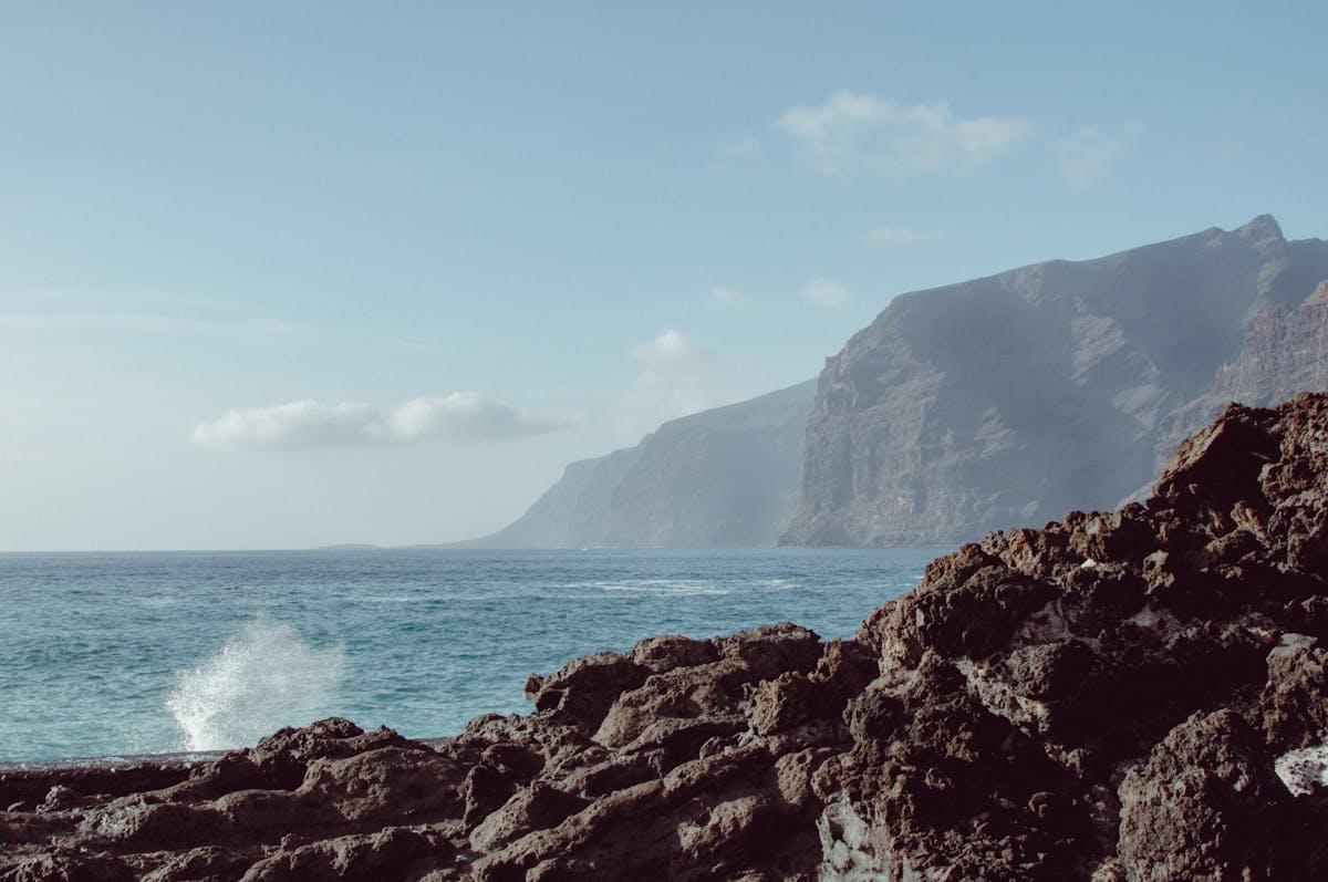 Ocean waves crashing against the rocky volcanic coastline of Tenerife Spain