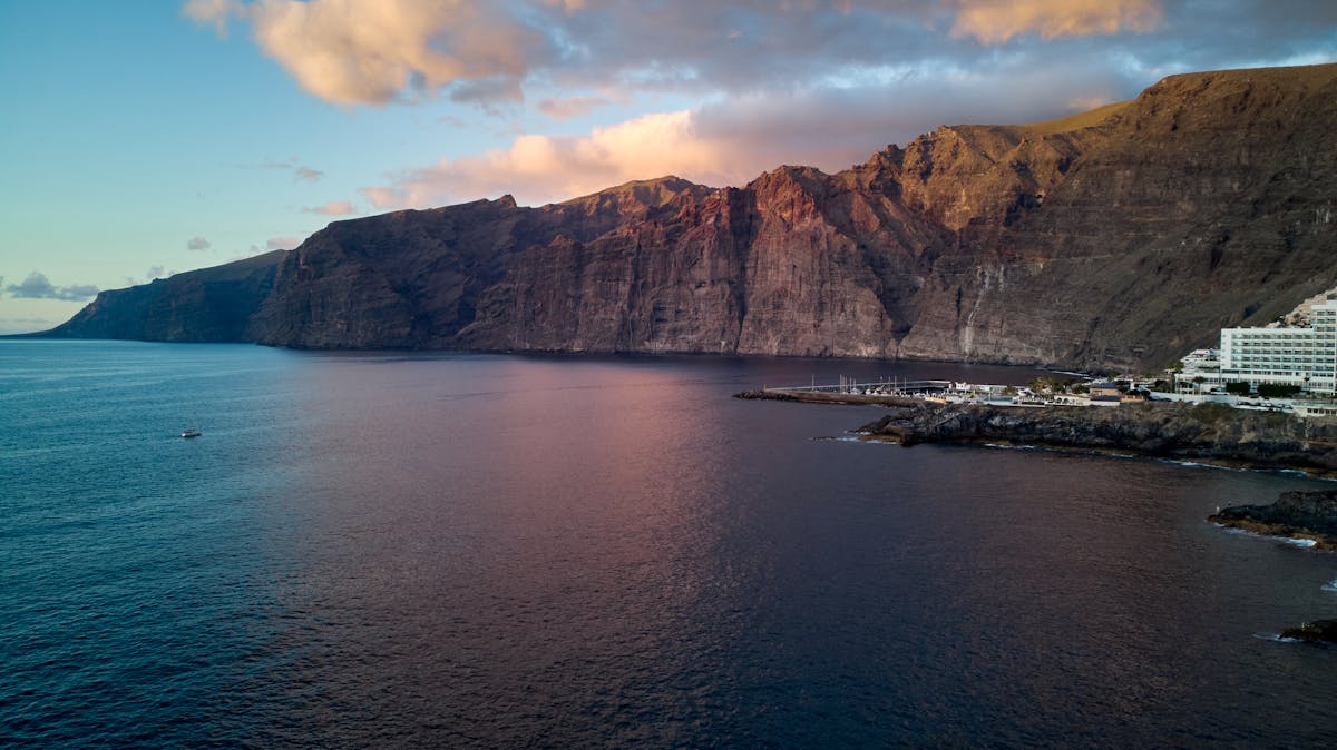 Stunning aerial view of Los Gigantes cliffs at sunset over the Atlantic Ocean