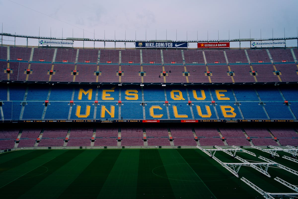 Camp Nou stadium seating showing the Mes Que Un Club motto spelled out across the stands