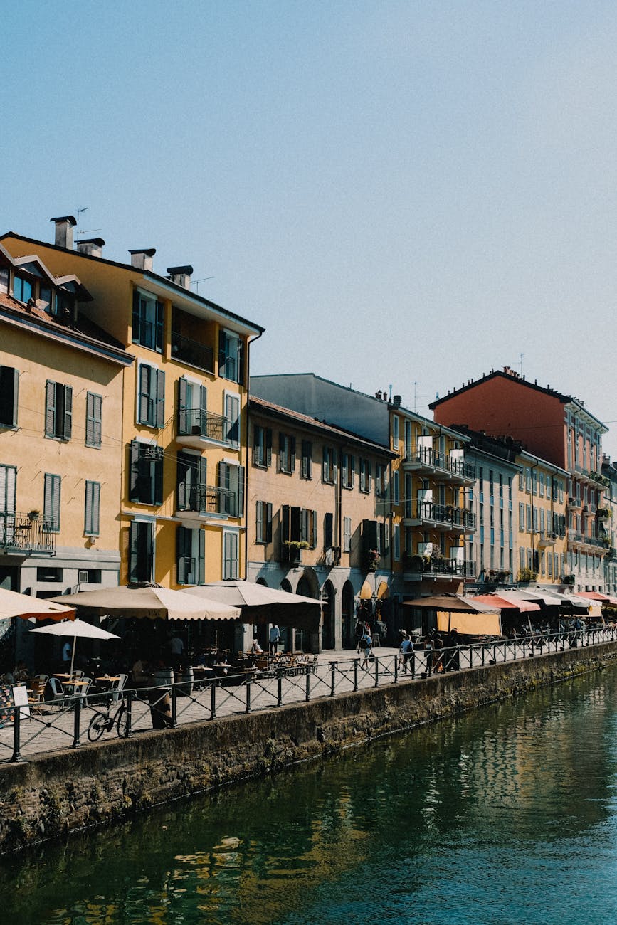 Canal with colorful rowhouses and outdoor cafe seating in the Navigli area