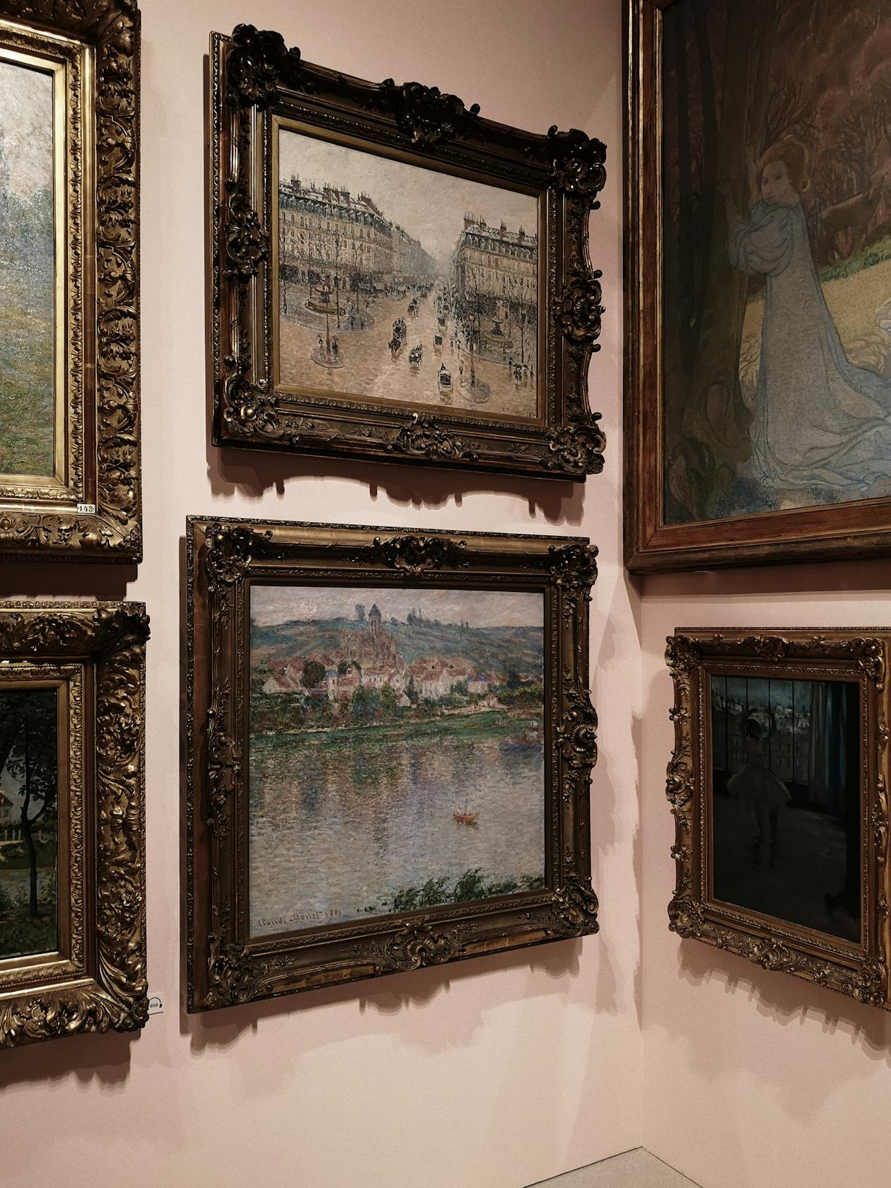 A gallery wall with classic paintings in ornate frames