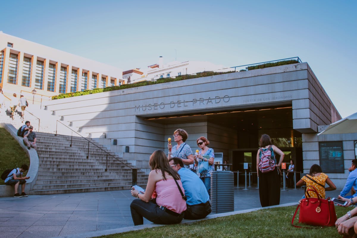 People enjoy a sunny day at the entrance of the Museo del Prado in Madrid, Spain
