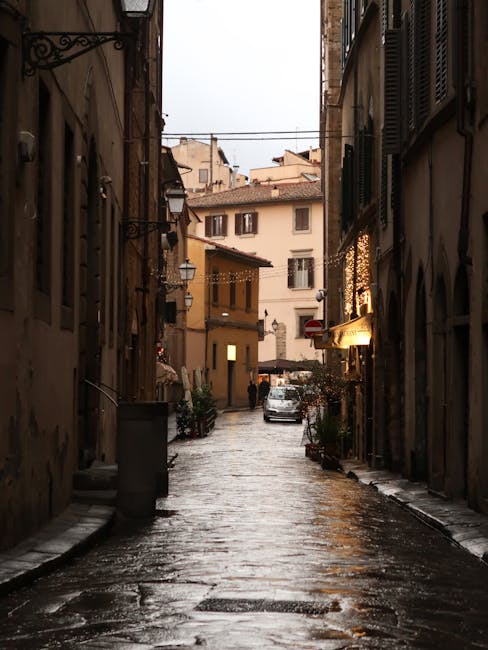 Cobblestone street in Florence at sunset with illuminated buildings on both sides