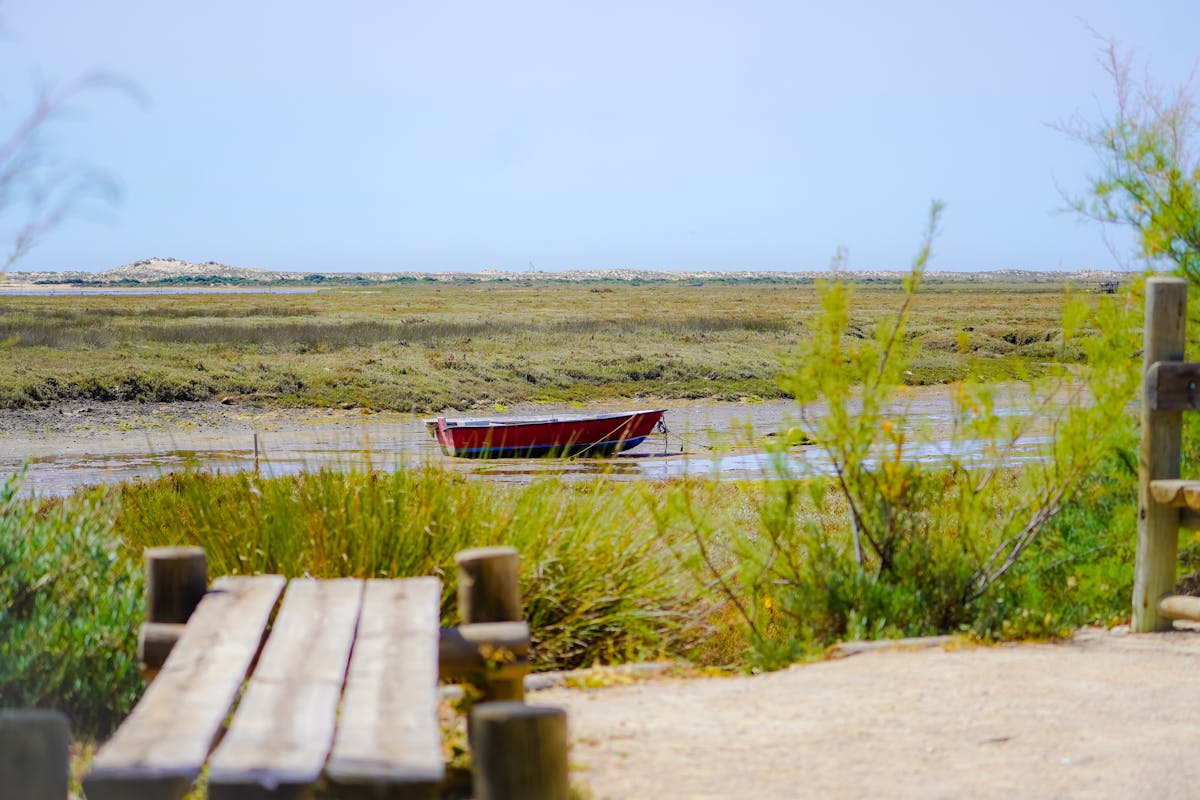 A traditional wooden boat sitting on the mudflats of Ria Formosa near Fuseta Portugal