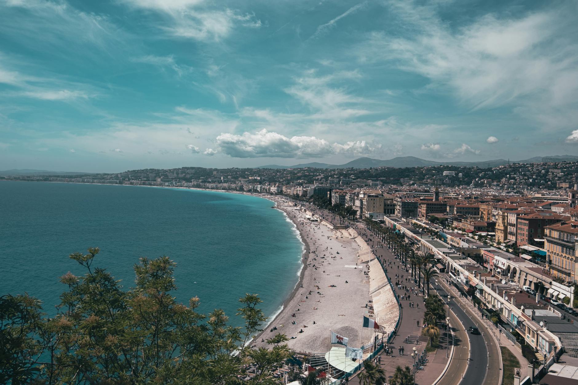 Aerial view of the azure coast near Nice showing turquoise water and red-roofed buildings along the shore