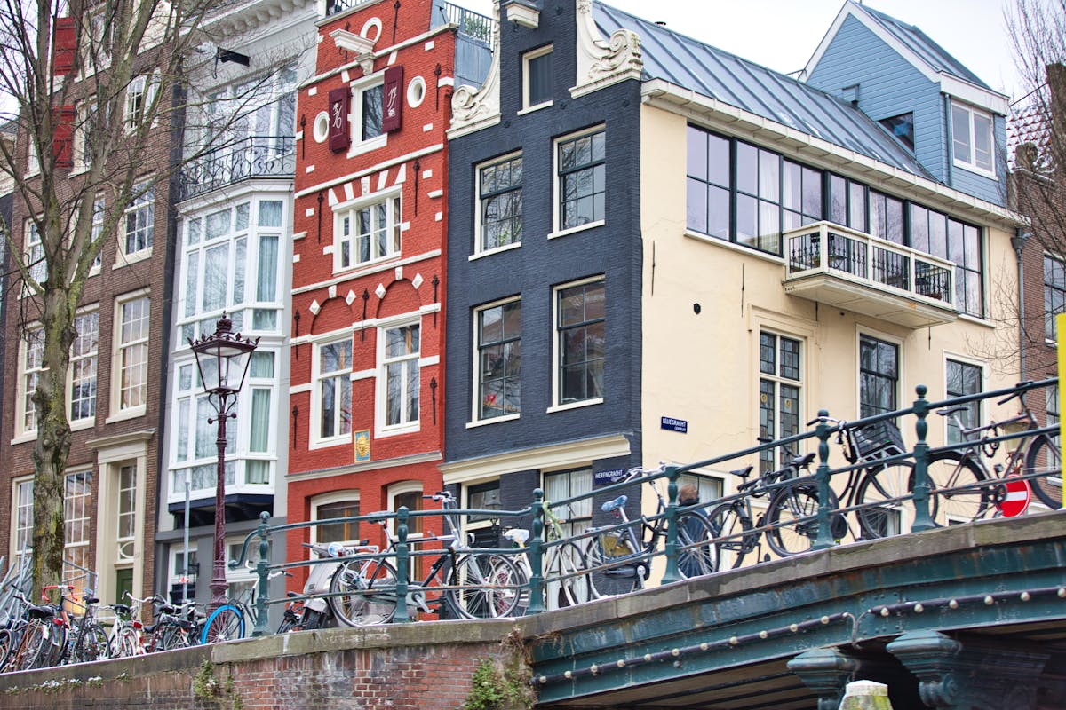 Bicycles lined up on an Amsterdam canal bridge with boats below