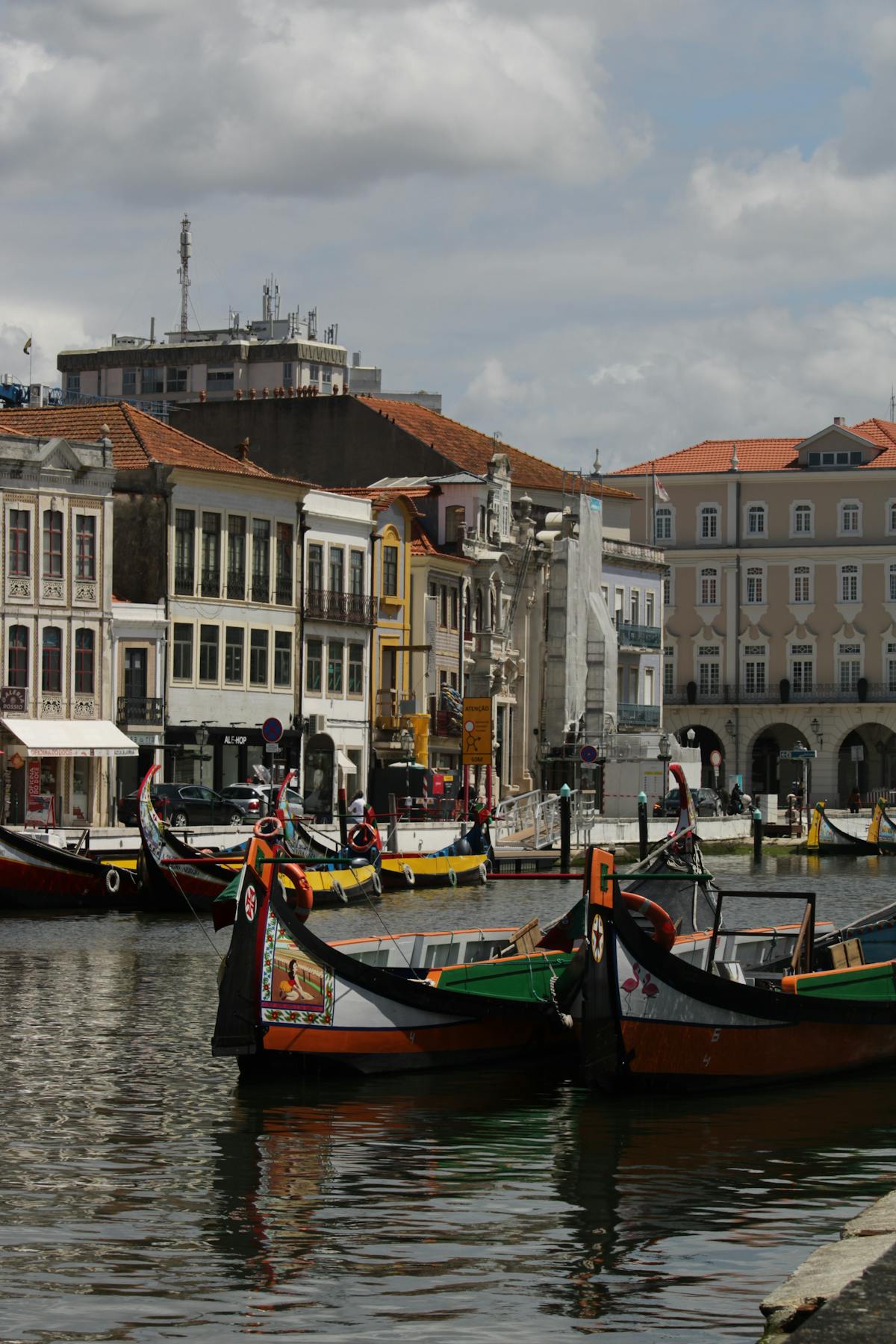 Traditional moliceiros floating on Aveiro canal with historic buildings in the background