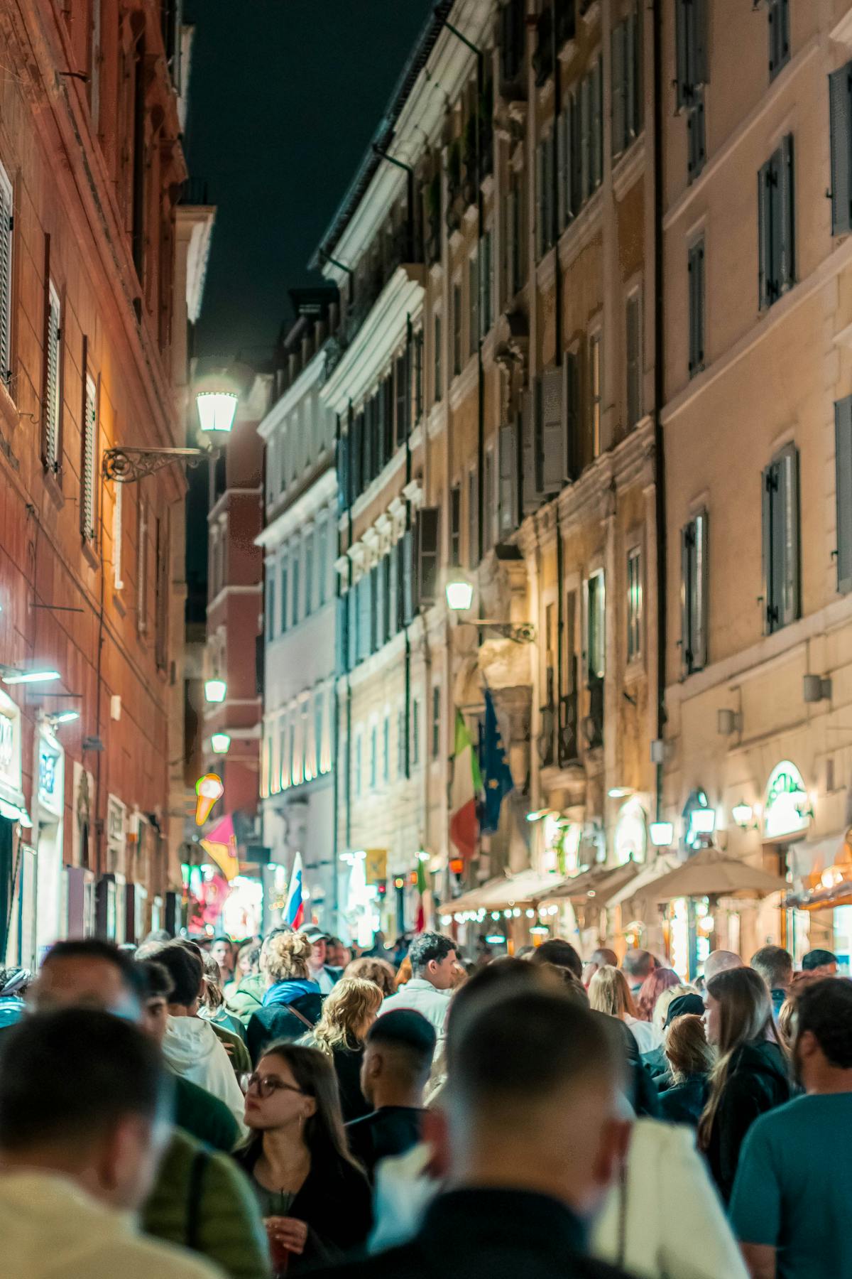 Lively street scene in Rome at night with restaurants and people