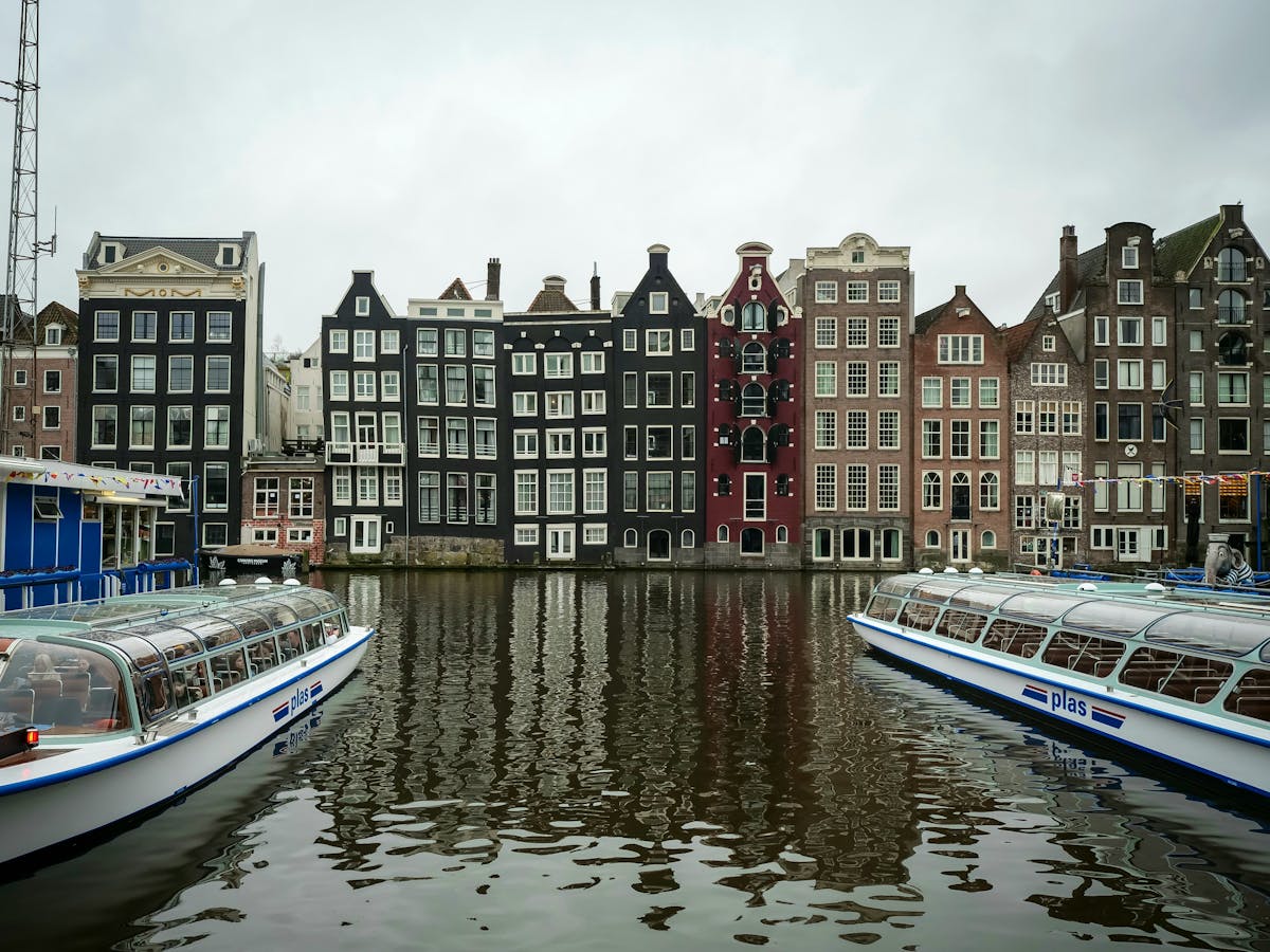 Tour boat passing colorful Amsterdam canal houses