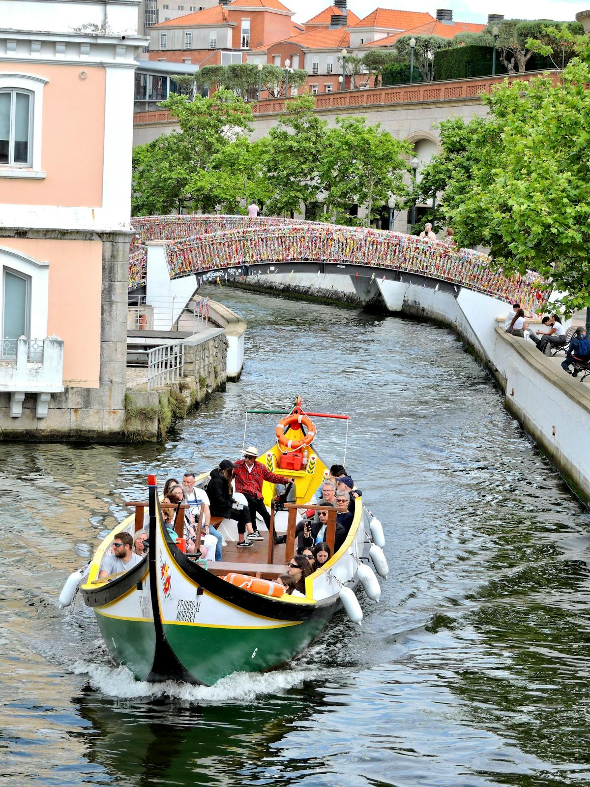 A moliceiro boat navigating beneath a charming footbridge in Aveiro