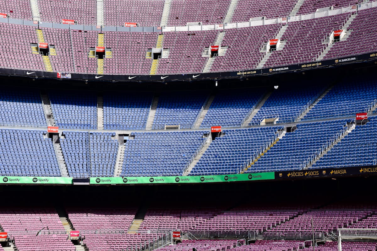 Wide-angle view of the empty stands at Camp Nou Stadium showing colorful seat patterns