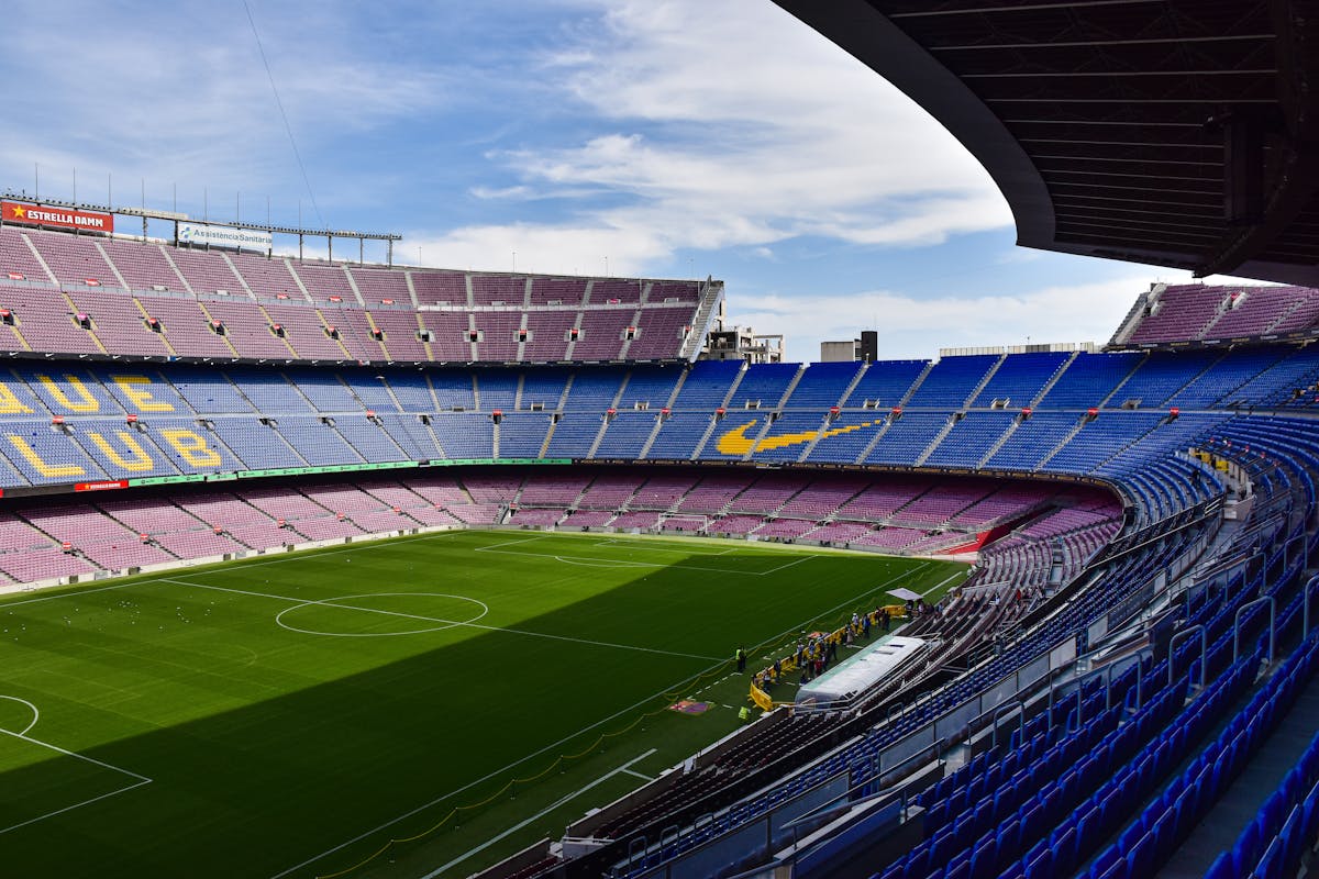 Wide view of the empty Camp Nou stadium showing its vast stands and green football pitch