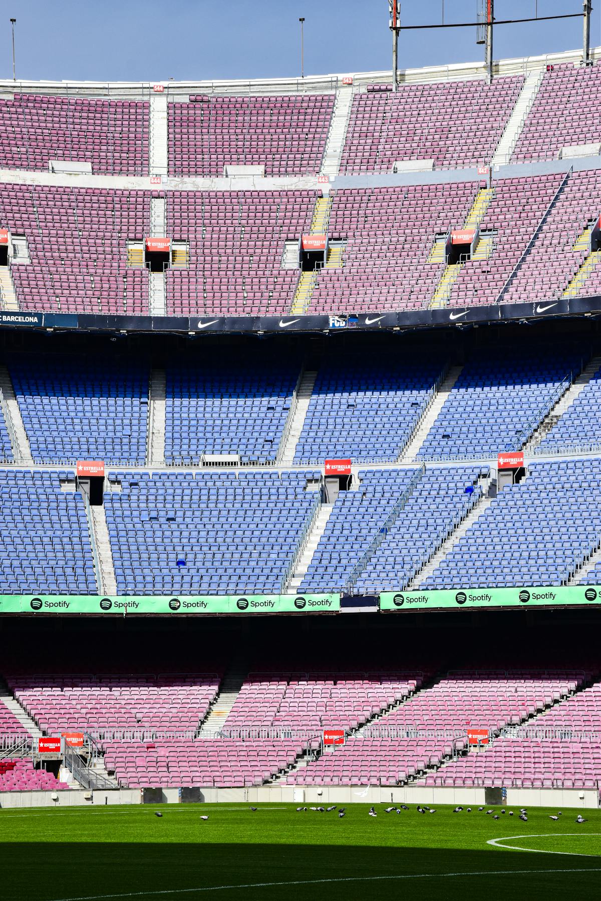 Empty Camp Nou Stadium in Barcelona with colourful rows of seats and a clear football pitch