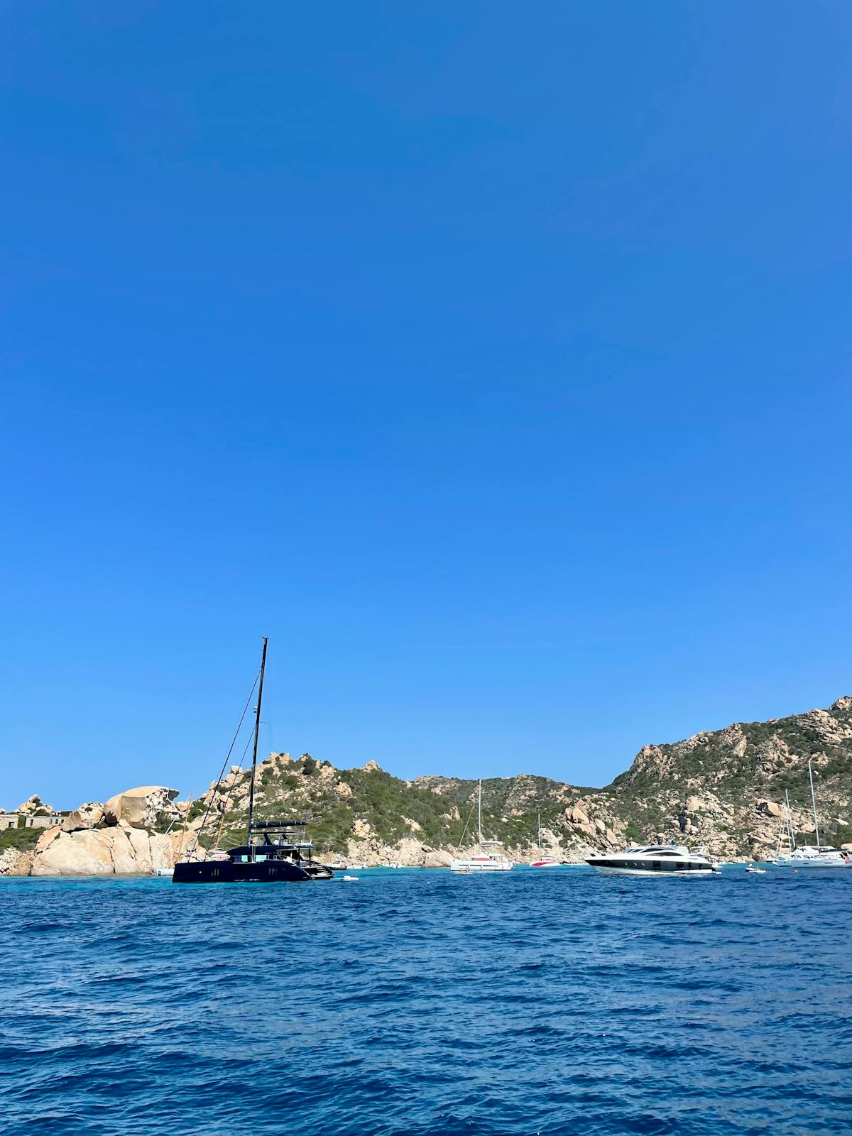 Rocky cliffs and tranquil blue water along the coast of La Maddalena Sardinia