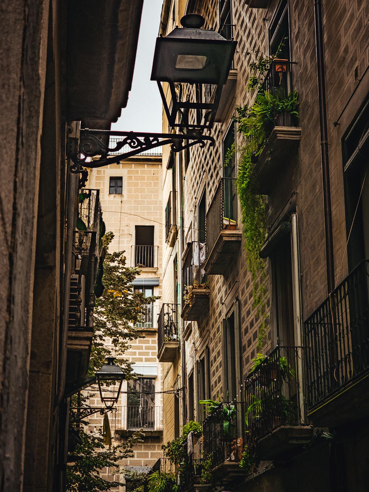 Narrow alleyway in the Jewish Quarter of Girona with vintage street lamps
