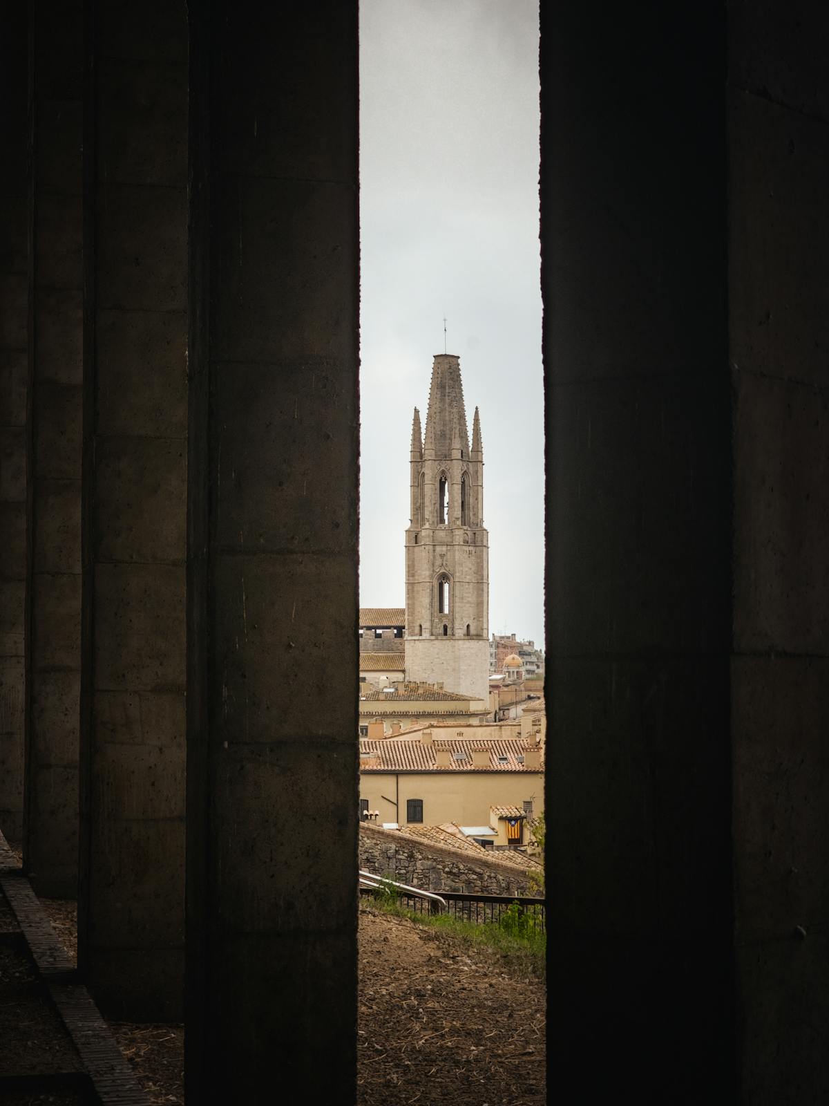 Historic tower in Girona framed by stone columns