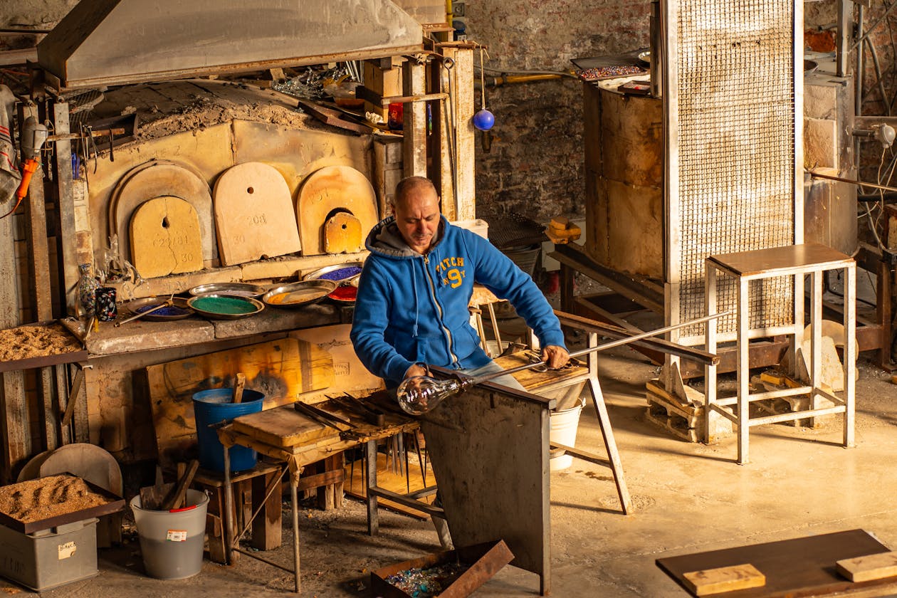 Glassblower crafting art in a traditional Murano glass workshop