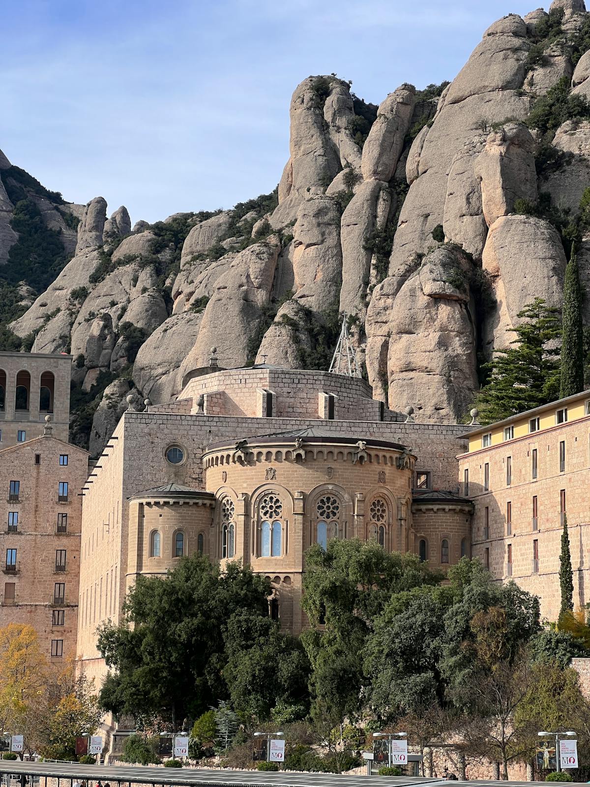A stone cross at a Montserrat hiking viewpoint with panoramic mountain views