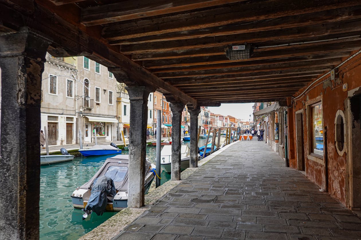 Rustic canal in Murano Italy with old buildings and moored boats