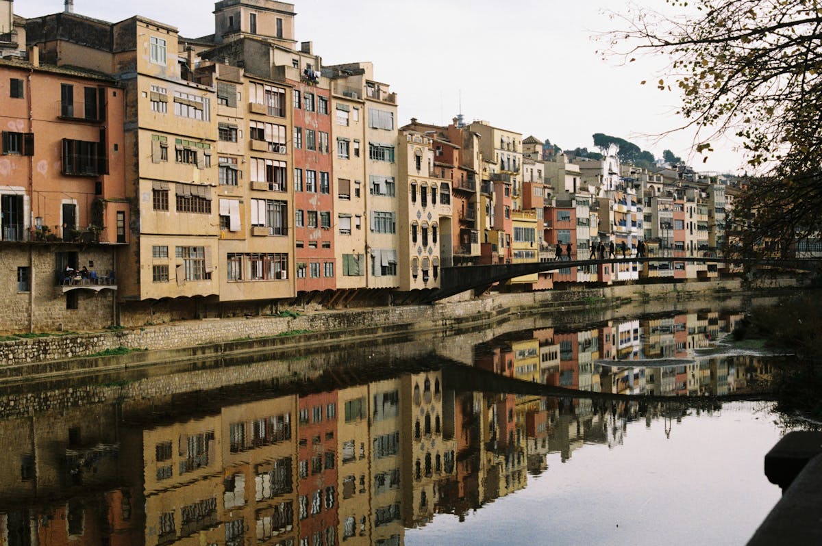 Historic buildings reflecting in the river in Girona Catalunya