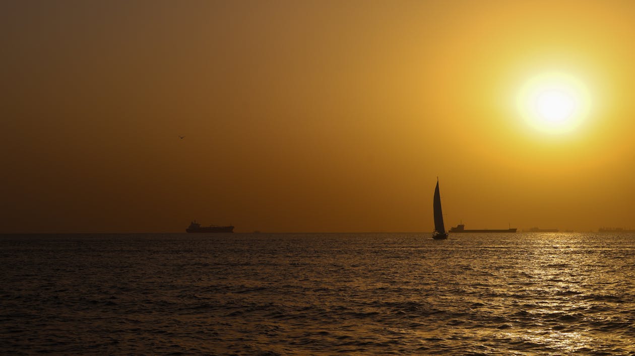 Sunset sailing scene with boats under an orange sky