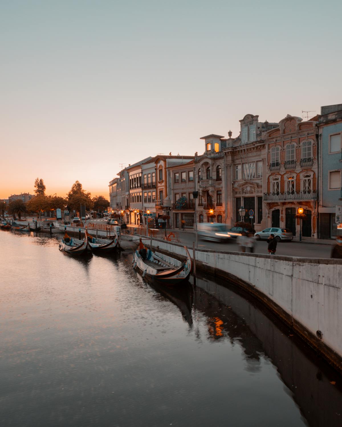Moliceiro boats lining the Aveiro canal at sunset with Portuguese architecture