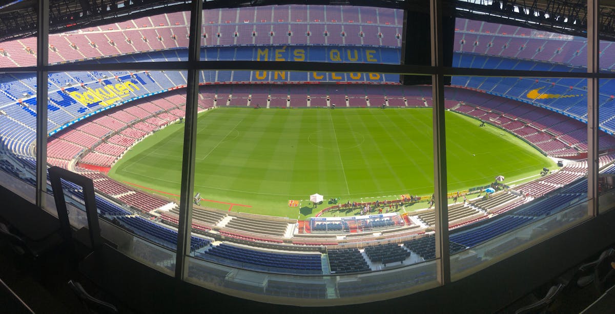 Wide view of Camp Nou stadium showing the vast seating area and green football pitch