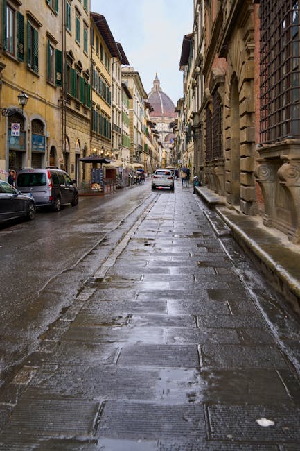 Wet cobblestone street leading toward the Florence Cathedral after rain