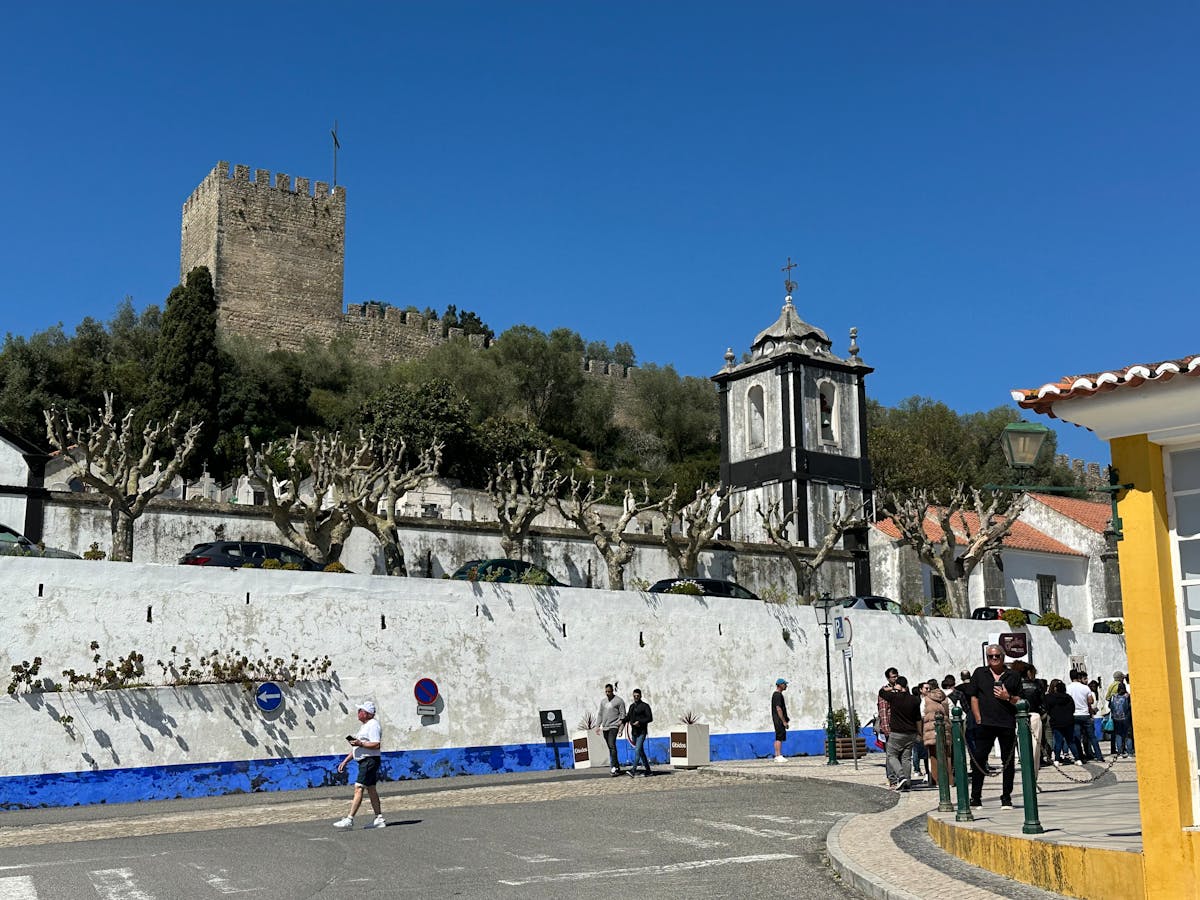 Obidos Castle with people walking along the narrow street in Portugal