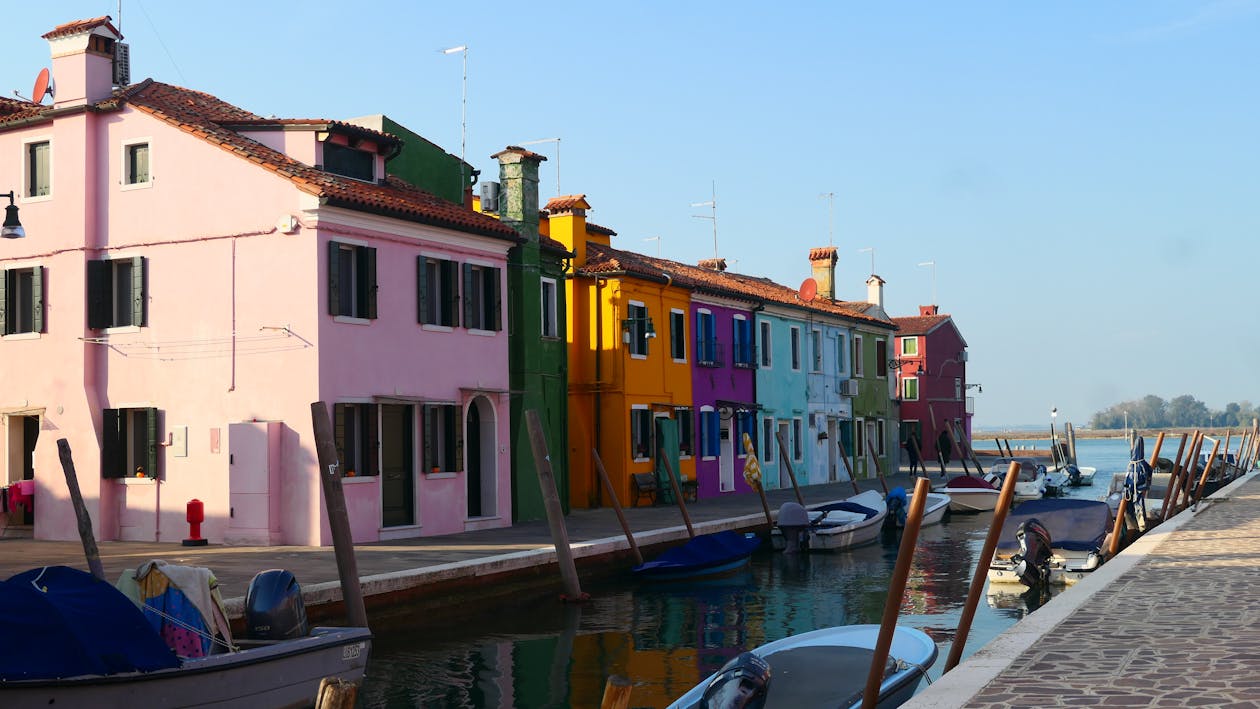Burano canal with colorful houses and boats on a sunny day