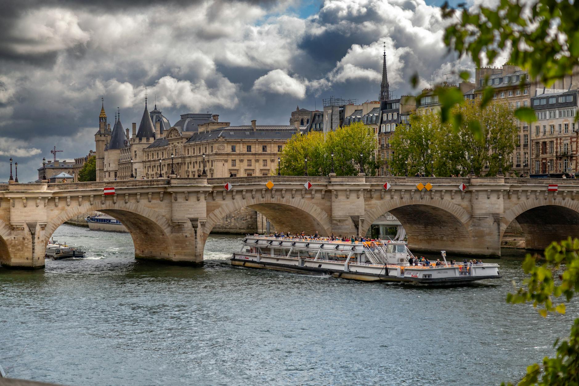 An arched stone bridge spanning the Seine with classic Parisian architecture behind it