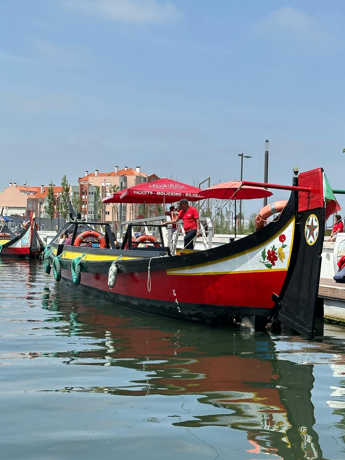 A traditional moliceiro boat with its vivid reflection in the waters of Ria de Aveiro