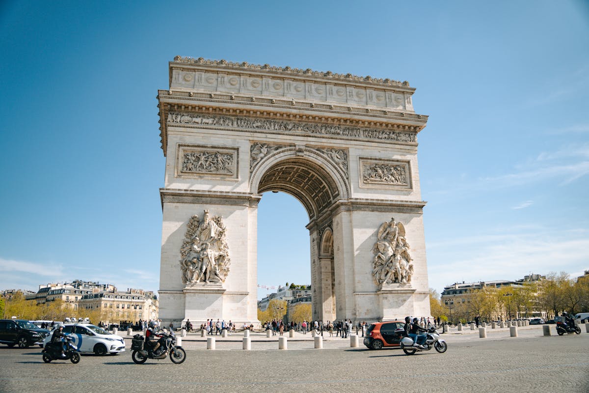 The Arc de Triomphe standing against a blue sky -- a key stop on the Tootbus route
